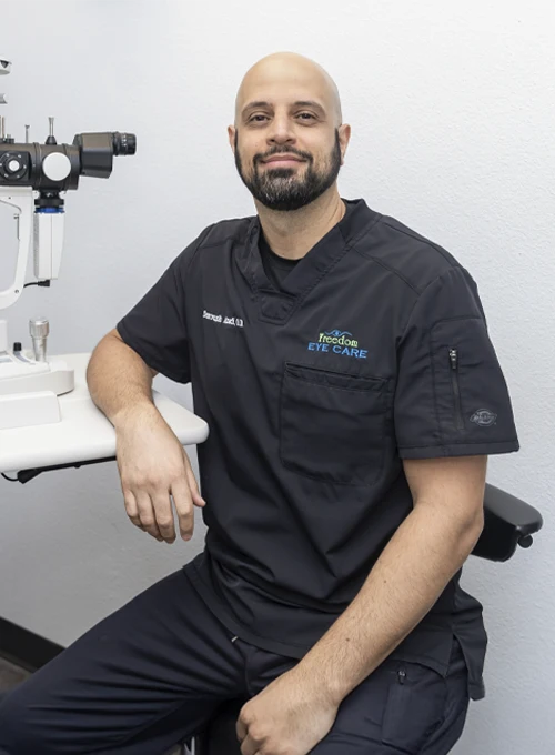 Dr. Soroush Azadi seated next to diagnostic instruments, showcasing a modern and professional clinical environment.